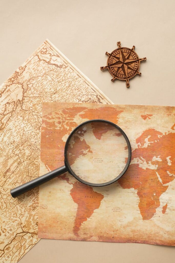 Magnifying glass and wind rose on maps